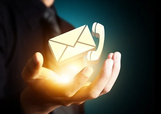 Mano sosteniendo íconos de correo y teléfono